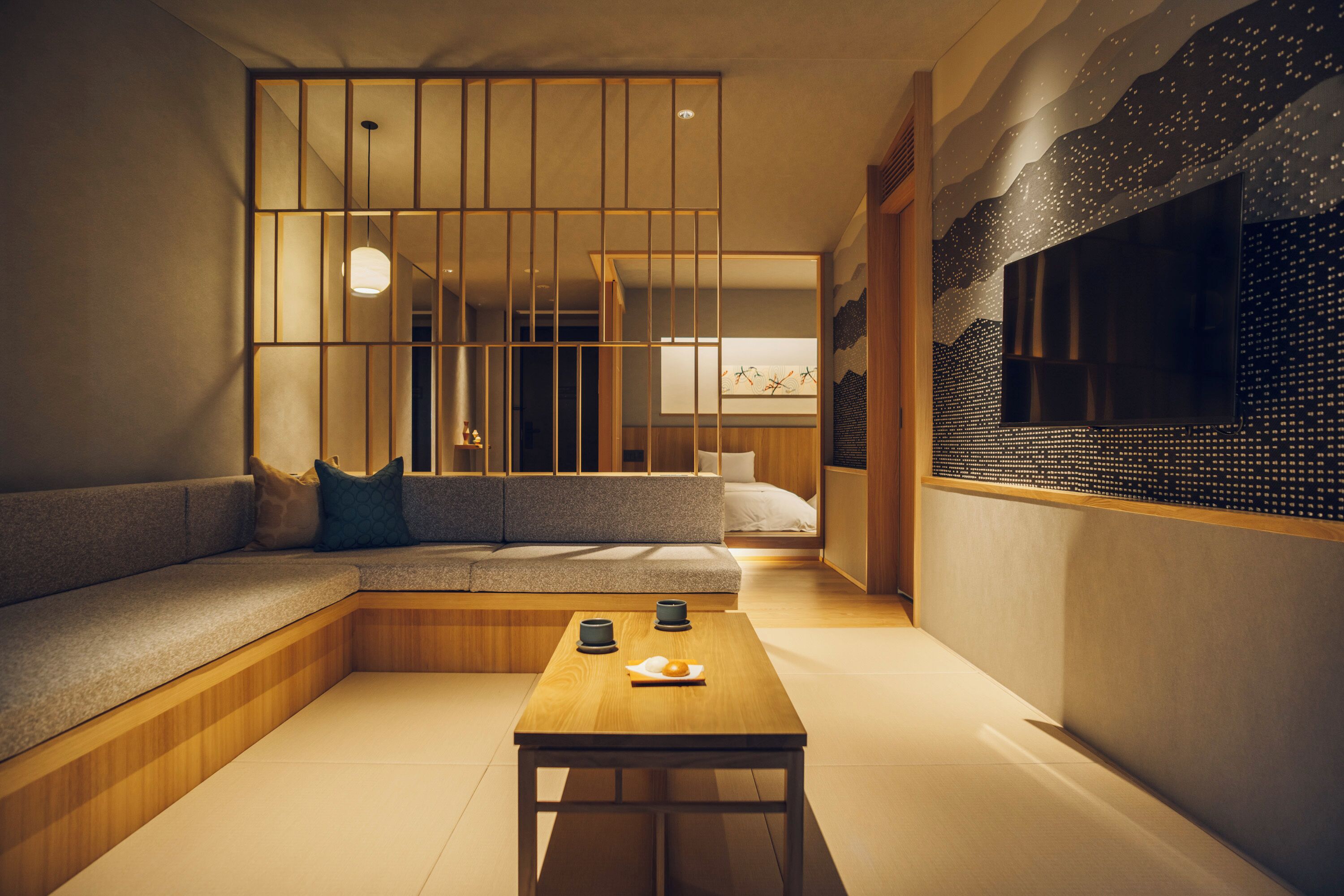 A modern interior with a sofa, a wooden table, and a decorative wall.