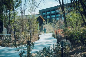 A pathway leading to a modern building with a glass facade. - Hoshino Resorts KAI Kusatsu (Kusatsu)