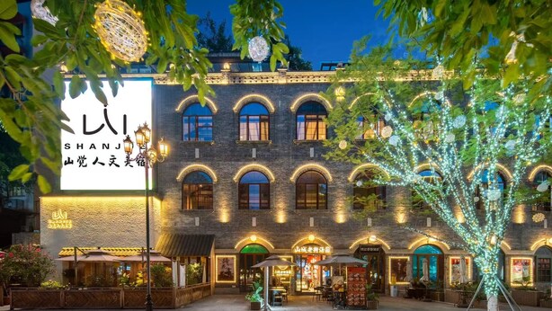 A traditional building with arched windows and a sign in a foreign language. - Shanjue Cultural Boutique Hotel-Nanbin (Chongqing)