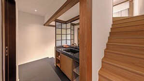 A modern kitchen with a wooden staircase and a view of the upper floor. - Shanjue Cultural Boutique Hotel-Nanbin (Chongqing)