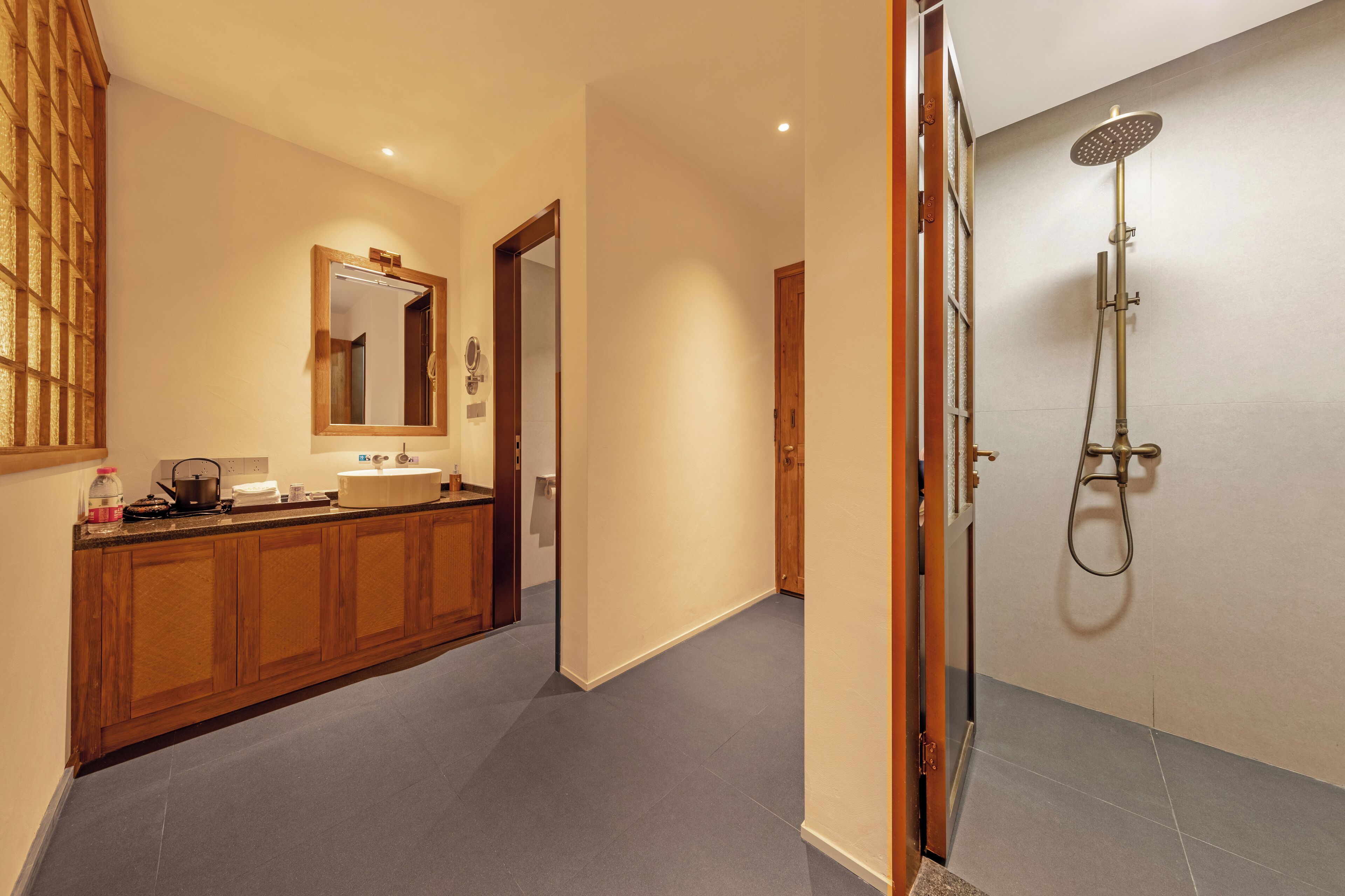 Une salle de bain moderne équipée d’une douche, d’un lavabo et d’un miroir.
