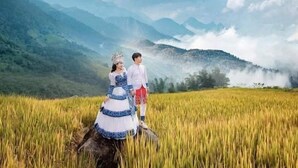 A couple standing in a field with mountains in the background. - To Ech Homestay (Sin Suoi Ho)