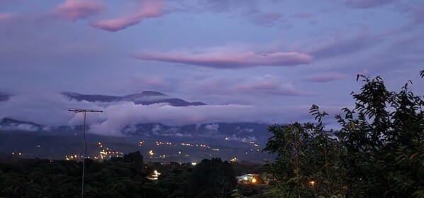 Eine Berglandschaft mit Blick auf eine Stadt im Abenddämmerung.