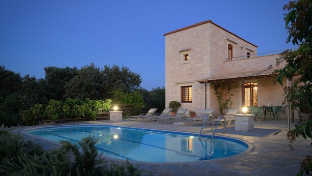A stone building with a pool, lounge chairs, and a well-lit outdoor area. - Villa Dione, 3 BDR, Forest Views, Private Pool, Furnished Terrace, Crete (Rethymno)