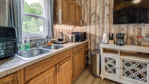 A kitchen with wooden cabinets, a microwave, a toaster, and a sink.