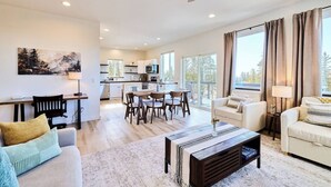 Un salon moderne avec un canapé, une table basse et un coin repas.