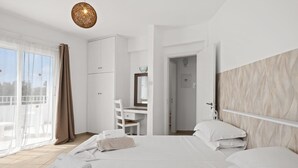 A hotel room with a bed, a desk, a chair, and a balcony with curtains. - Villa Kallidora, 4 BDR, Private Pool, Furnished Terrace, Ayia Napa, Cyprus (Famagusta)