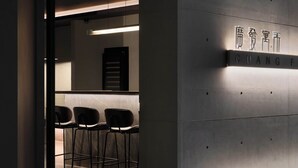 Un intérieur moderne comprenant un comptoir d’accueil, un bar et un espace salon.