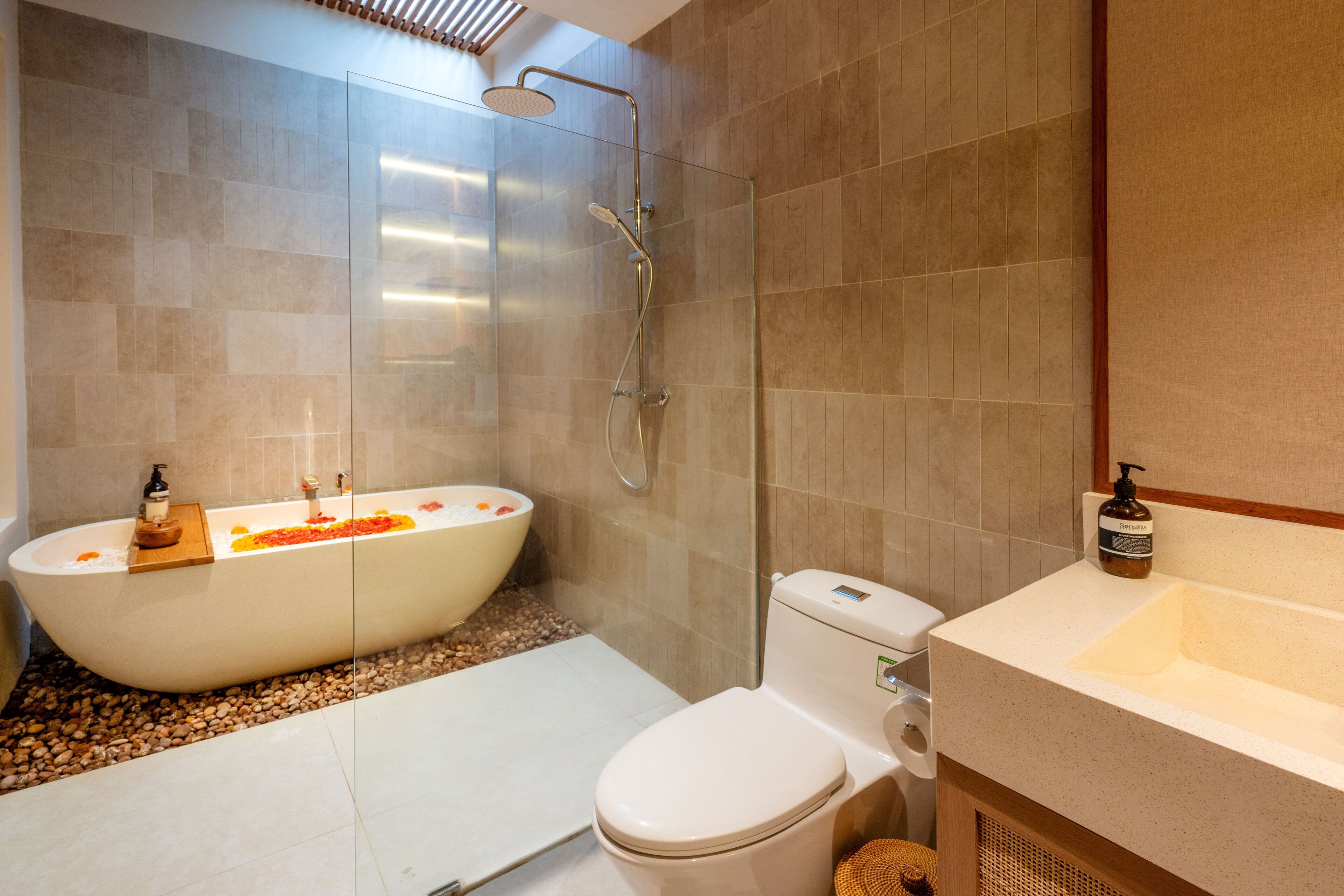 Een aparte badkuip en douche, een haardroger, handdoeken, zeep