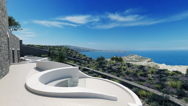 Een modern terras buiten, met een gebogen witte constructie, met uitzicht op een kustlandschap met een helderblauwe lucht en de zee.
