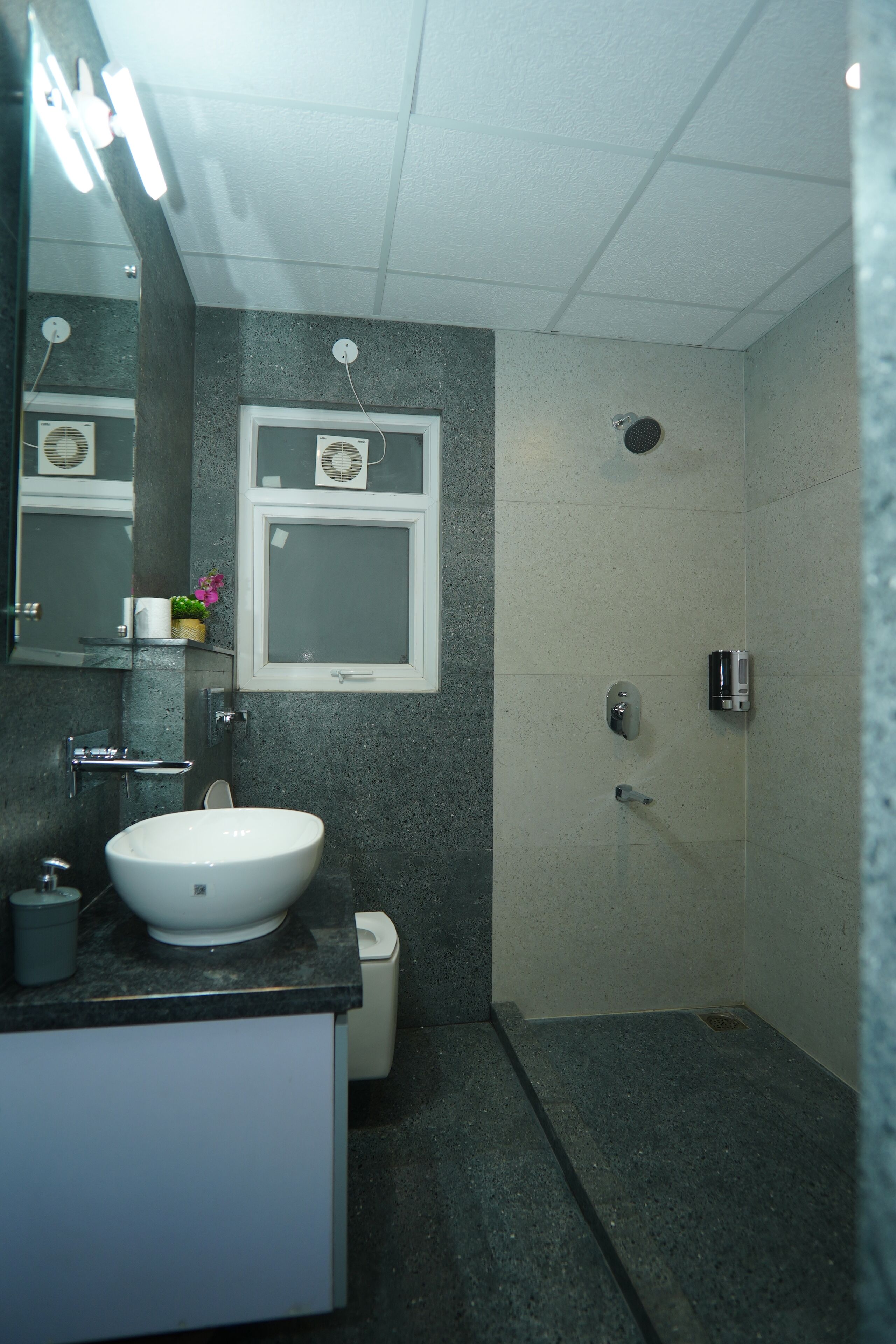 A bathroom with a white sink, mirror, and shower.