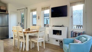 Een moderne keuken met witte kasten, een ingebouwde oven en een grote flatscreen televisie boven de open haard.