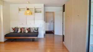 A modern living room with a built-in bench, a hanging light fixture, and a wooden wardrobe. - Mountain Loft - DuLac 33 (Sankt Moritz)