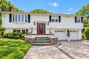 A two-story house with a red front door, stone steps, and two deer statues. - Spacious Yard w/ Gazebo: Charming Windsor Retreat (Windsor)