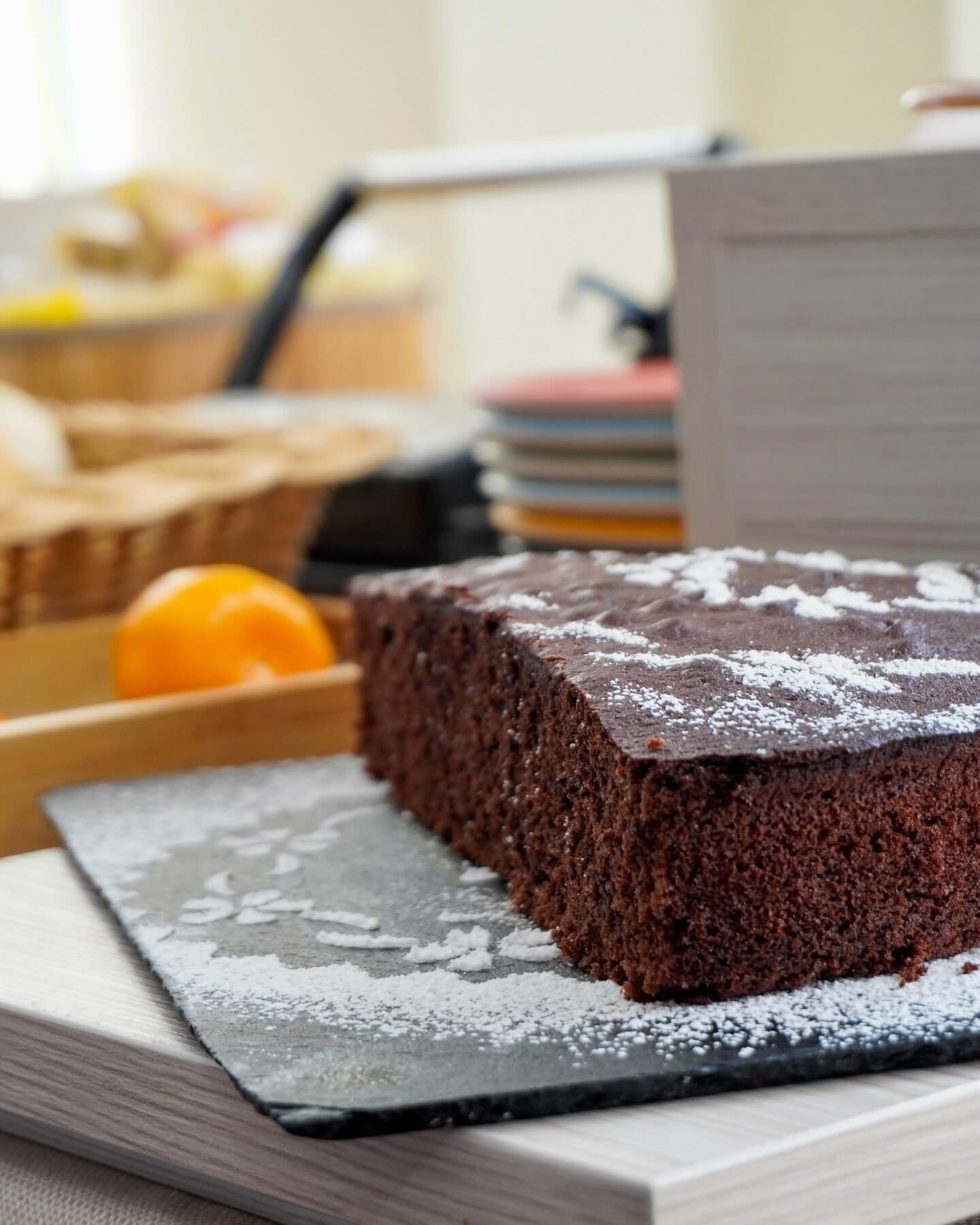 Una porción de pastel de chocolate sobre una bandeja de pizarra.
