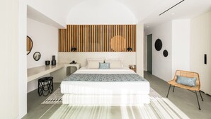 Een moderne slaapkamer met een groot bed, een wand van houten latten, een rieten stoel en een klein nachtkastje.