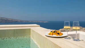 A poolside view with a clear sky, a plate of fruit, and two glasses of white wine. - Auriane Suite, Divine Sunset & Sea Views, Private Pool & Jacuzzi, Furnished. (Santorini)