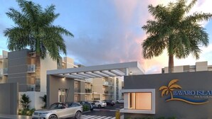 A modern building with a covered entrance, palm trees, and a sign for Bavaroi Island Residence. - Moderno Apto en B Varo Island Piscina Playa (Punta Cana)