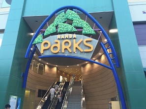 Ein Schild für Namba Parks mit einer Rolltreppe.