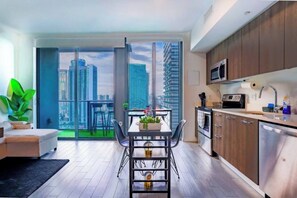 A modern apartment with a balcony, a dining area, and a kitchen. - Premium Studio Near Bayside Pool Gym Views (Miami)