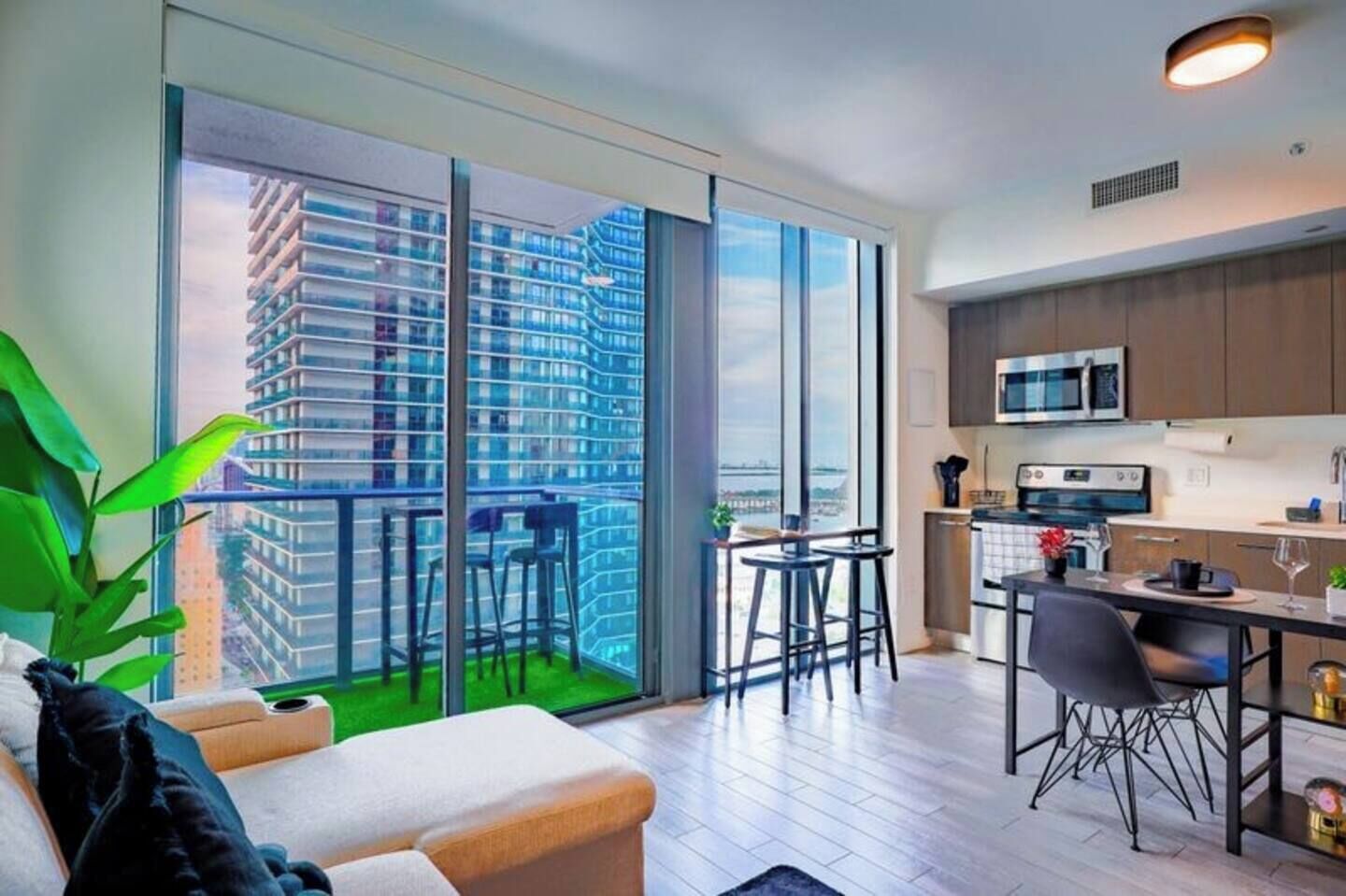 A modern apartment with a balcony, a kitchen, and a dining area.