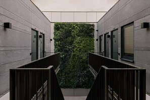 A modern building with a central atrium featuring a vertical garden wall. - Hotel Rose Rotterdam (Rotterdam)