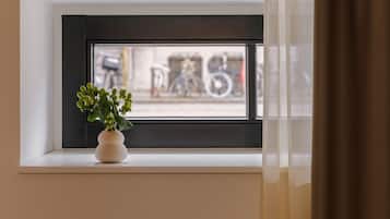 Une fenêtre avec un cadre blanc et une petite plante en pot posée sur le rebord.