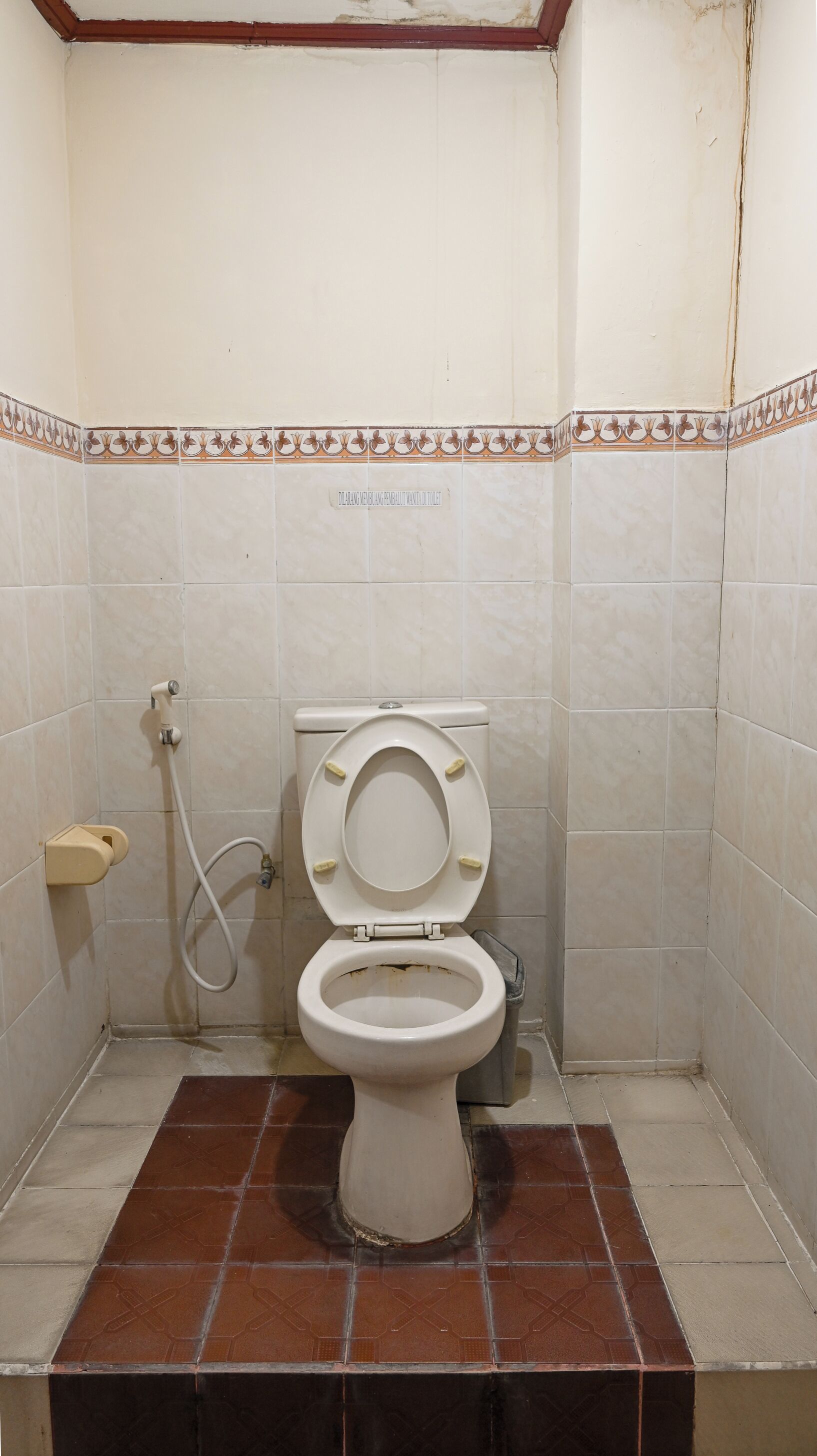 Un baño pequeño con inodoro, ducha y piso de baldosas.
