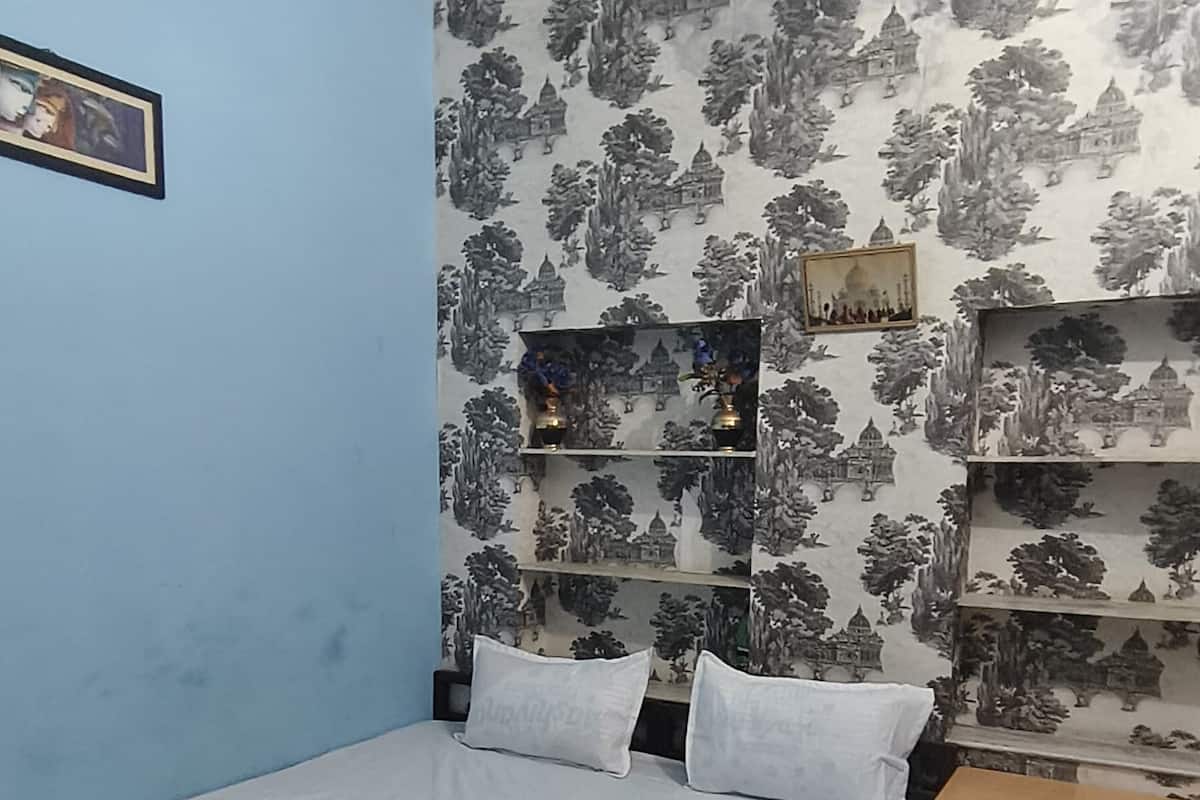 A bedroom with a bed, a desk, and a chair.
