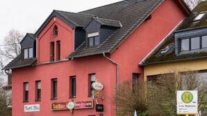 Un bâtiment rouge orné de nombreuses enseignes, dont « Sultin » et « Brew & Bake ».