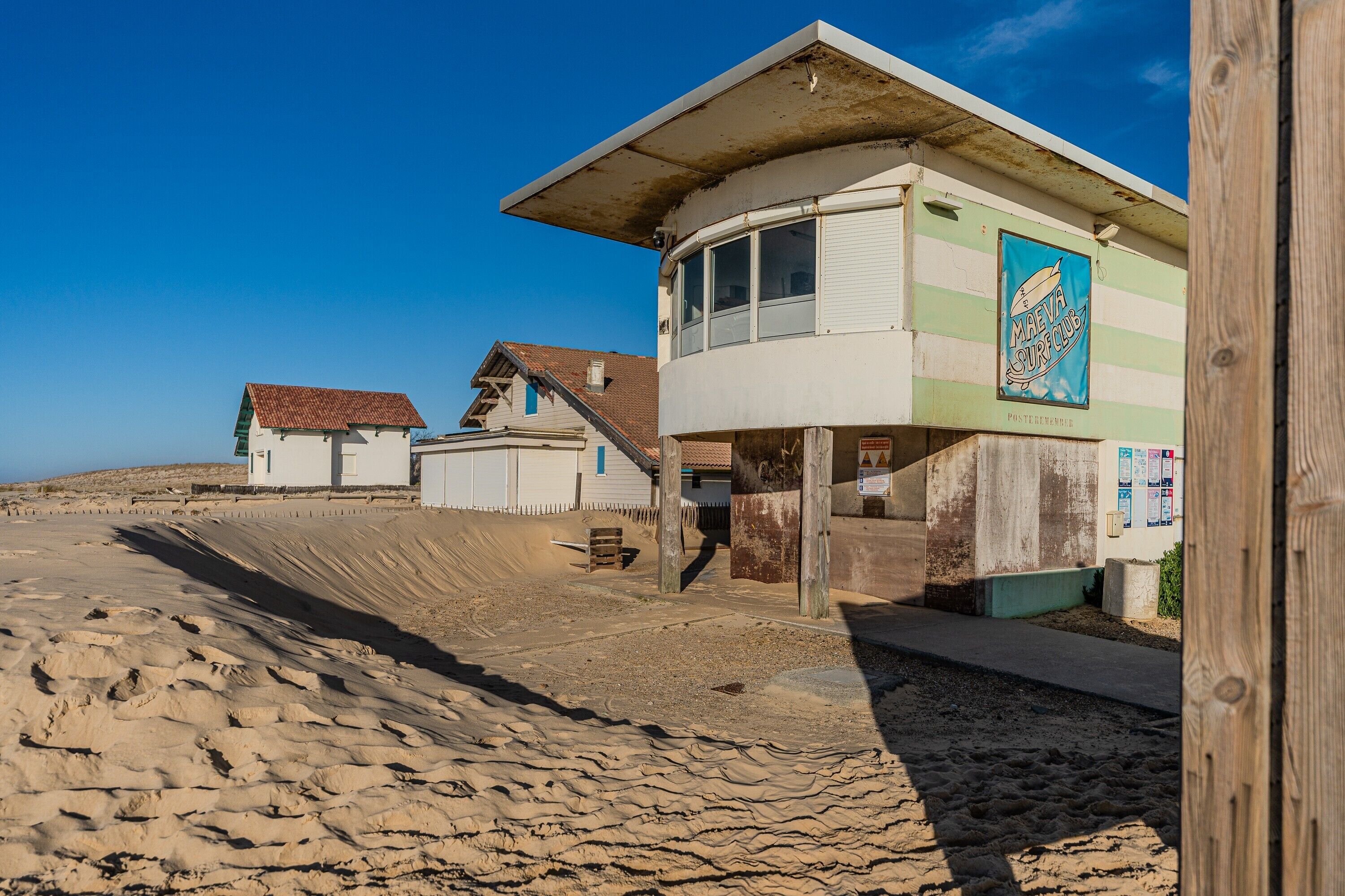 Un bâtiment situé en bord de mer, sur lequel on peut lire l’inscription : « MAEVA SURF CLUB ».