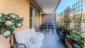 A balcony with a sofa, a table, chairs, and potted plants. - “Côté Dunes Mimizan” Apartment – Your Escape Between Ocean and Nature in Mimizan (Mimizan)