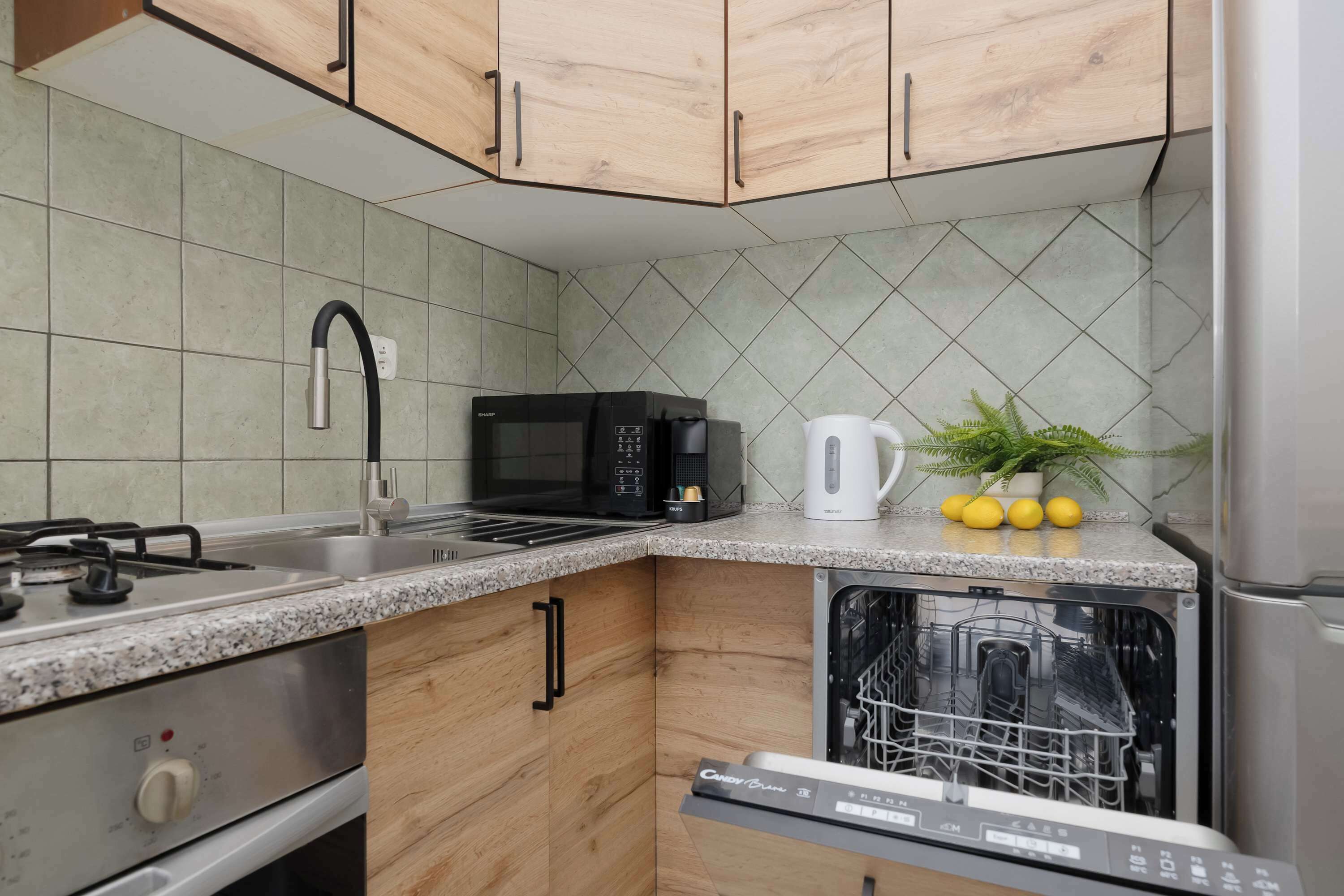 A kitchen with wooden cabinets, a stainless steel stove, a microwave, a dishwasher, and a sink.
