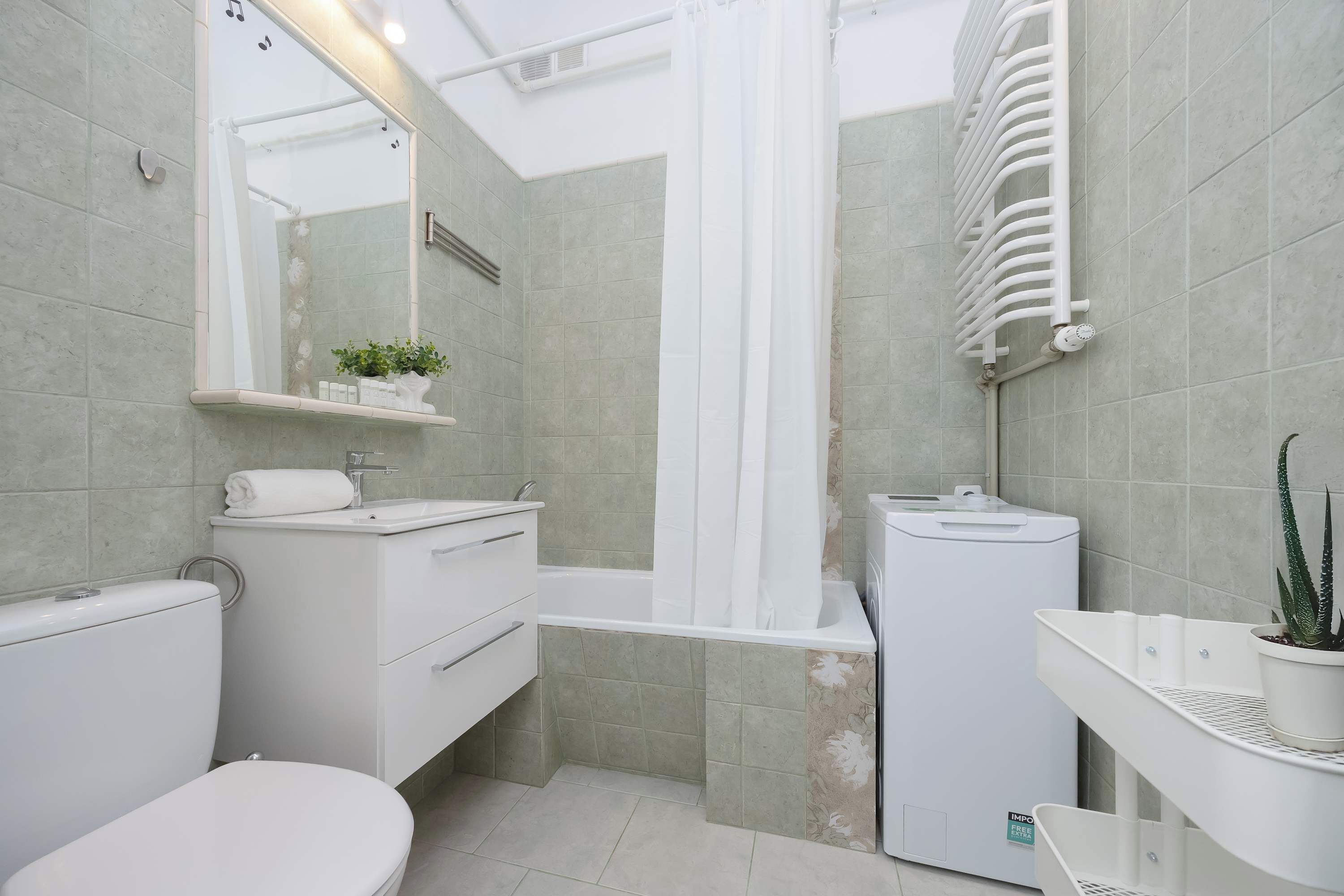 Une salle de bain moderne équipée de toilettes, d’un lavabo et d’une zone douche.