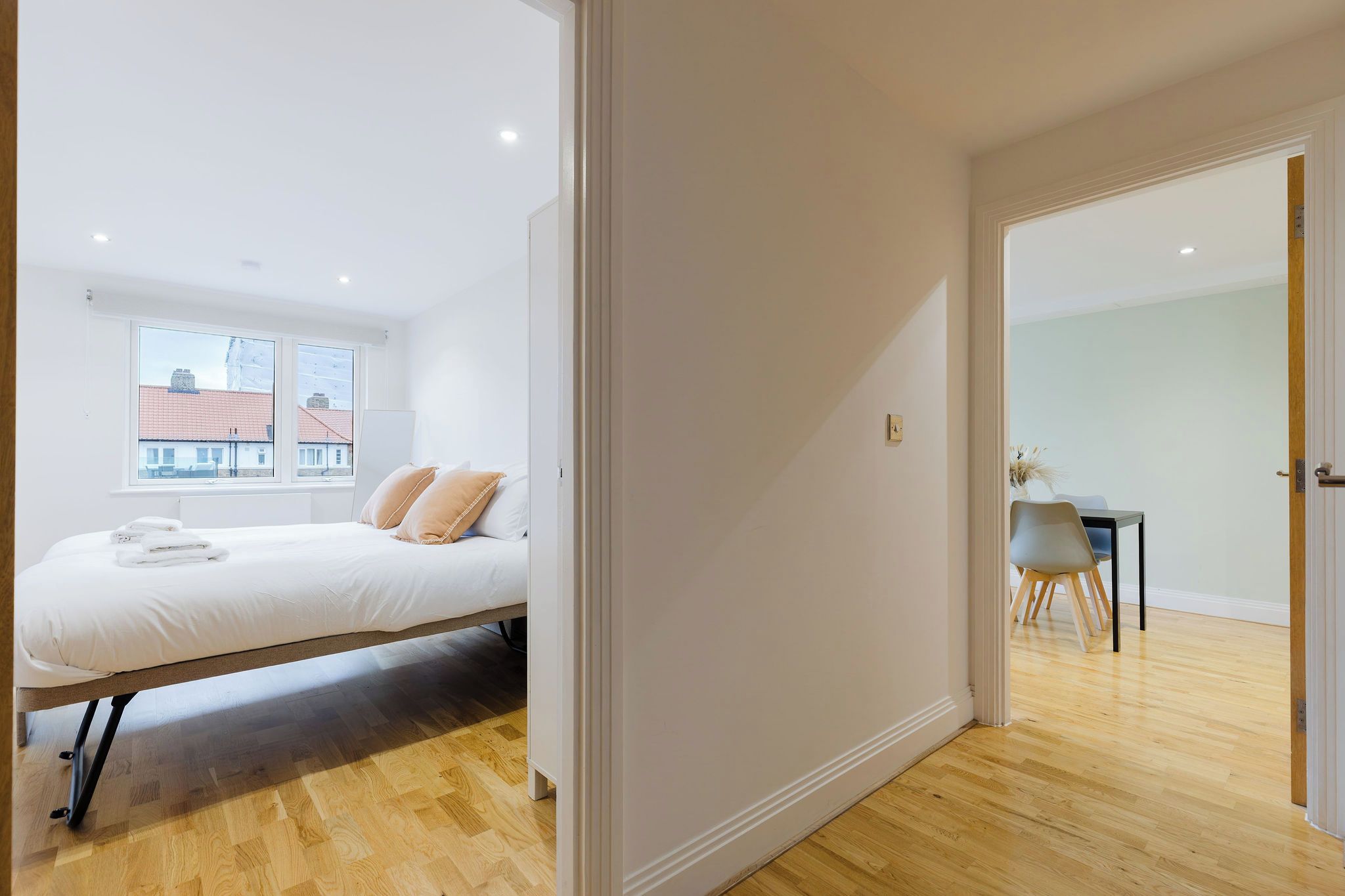Une chambre à coucher avec un lit, une fenêtre et une vue sur les bâtiments environnants.