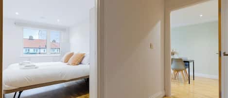Une chambre à coucher avec un lit, une fenêtre et une vue sur les bâtiments environnants.