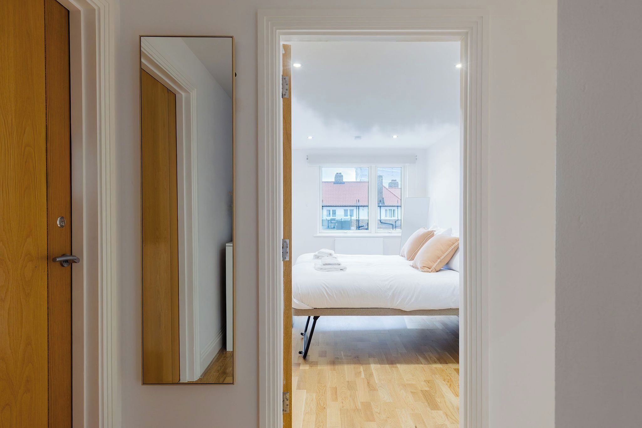 Ein Schlafzimmer mit einem Bett, einem Fenster und Blick auf Gebäude.