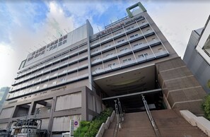 A multi-story hotel with a modern architectural design, featuring a prominent entrance with a covered area and a staircase leading to the entrance. - 2 Units Same Floor/30sec Tsutenkaku/1 stop Namba 6 (Naniwa-ku, Osaka City)