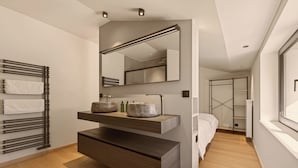 Een moderne badkamer met een ingebouwde wastafel, een handdoekhouder en een grote spiegel.