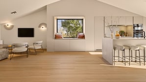 Een modern interieur met een loft-plafond, een groot raam met uitzicht, een keukenhoek en zitplaatsen.
