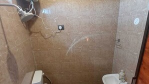 A small bathroom with a toilet, bidet, and sink. - The Rana Resort (Jogindarnagar)