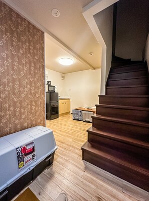 A staircase leading to a second floor, a kitchen area with appliances, and a patterned wall. - meisei ebiyaminami (Osaka)