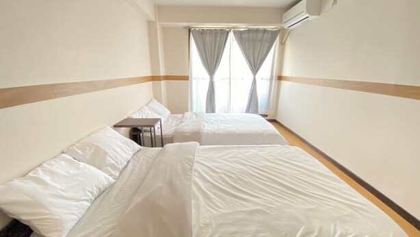 A hotel room with two beds, a small table, and a window with curtains. - 2 Units Same Floor/30sec Tsutenkaku/1 stop Namba 5 (Naniwa-ku, Osaka City)