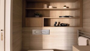 A bathroom with wooden shelves, a towel rack, and a toilet. - Superb air-conditioned apartment - Le Marais (Paris)