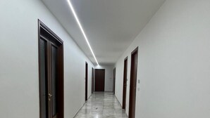 A long, narrow hallway with a marble floor and white walls, leading to a door at the end. - M9 REST HOUSE VENICE (Mestre)
