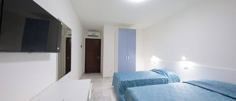 Habitación triple Confort, vistas a la ciudad | Escritorio, wifi gratis, ropa de cama