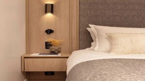 A modern bedroom with a wooden nightstand, a wall-mounted light, and a decorative vase. - Elegant apartment - AC- 2BR-6P- le Marais (Paris)