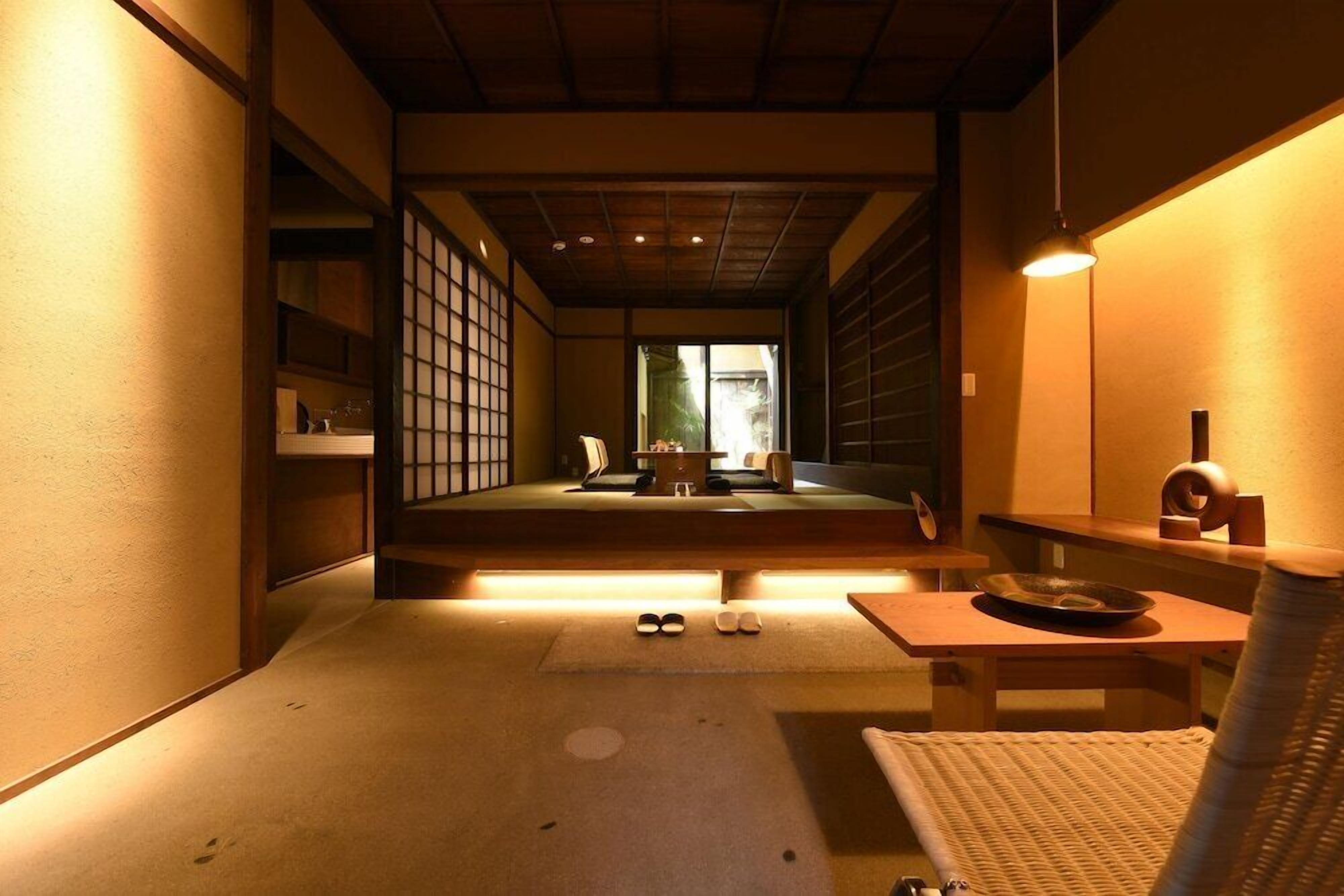 A traditional Japanese room with tatami flooring, a low table with a bowl, and sliding doors.