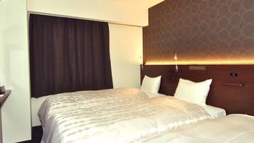 A hotel room with a large bed, a headboard with a patterned design, a bedside table, and a window with curtains.