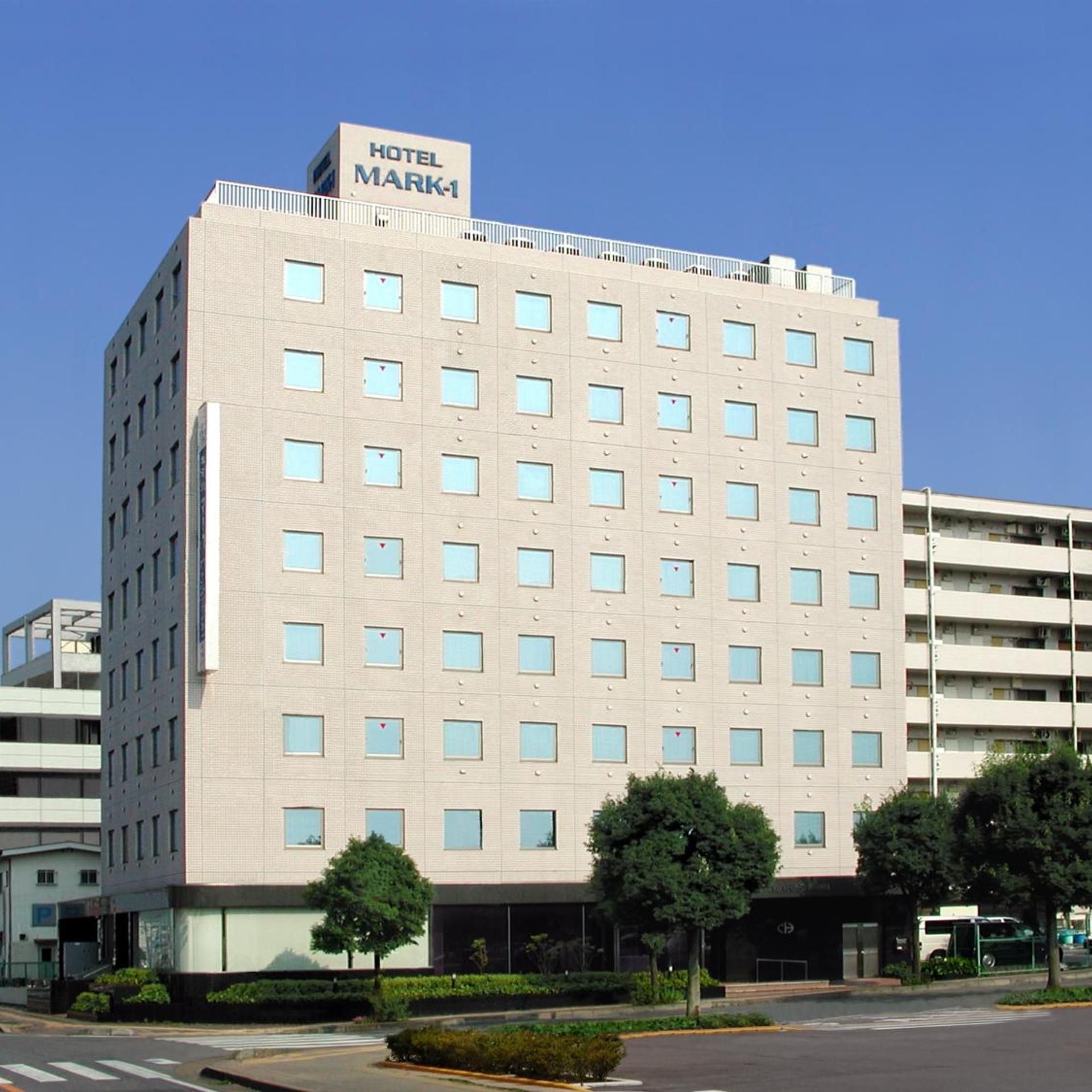 Un edificio de hotel de varios pisos con un letrero que dice 'HOTEL MARK-1' en la parte superior.